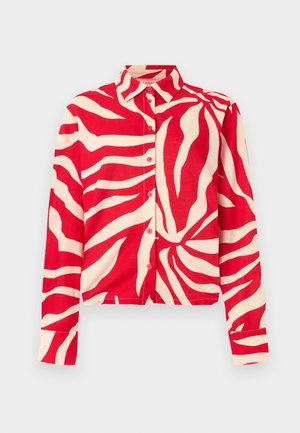 Πουκάμισο μακρυμάνικο με κουμπιά, με κόκκινες και κρεμ αφηρημένες ρίγες ζέβρας, μυτερό γιακά και μανσέτες στα μανίκια, πάνω σε ανοιχτόχρωμο φόντο.