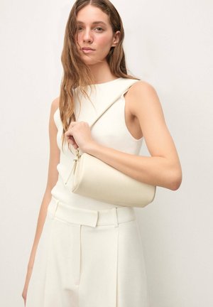 Bela usnjena torbica s ramenskim trakom, okrogle oblike in dolgim trakom. Torbica ima gladko teksturo in subtilen zadržni zapiralo.