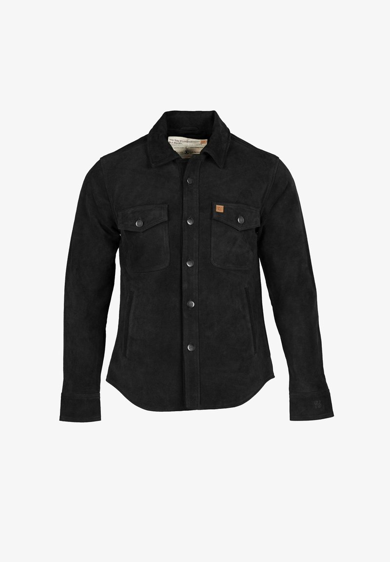 Melna zamšādas jaka ar pogām priekšpusē, divām krūšu kabatām, sānu kabatām un punktētu apkakli. Uz krūtīm ir smalka zīmola etiķete.