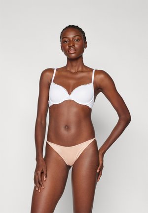 White lace-trimmed bra with smooth cups, paired with a beige low-rise bikini bottom. Both are simple in design and fit closely to the body.