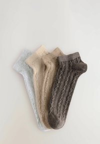 Vier paar gebreide sokken in grijs, beige, roomkleurig en donkerbruin, met gestructureerde patronen en geribbelde boorden.