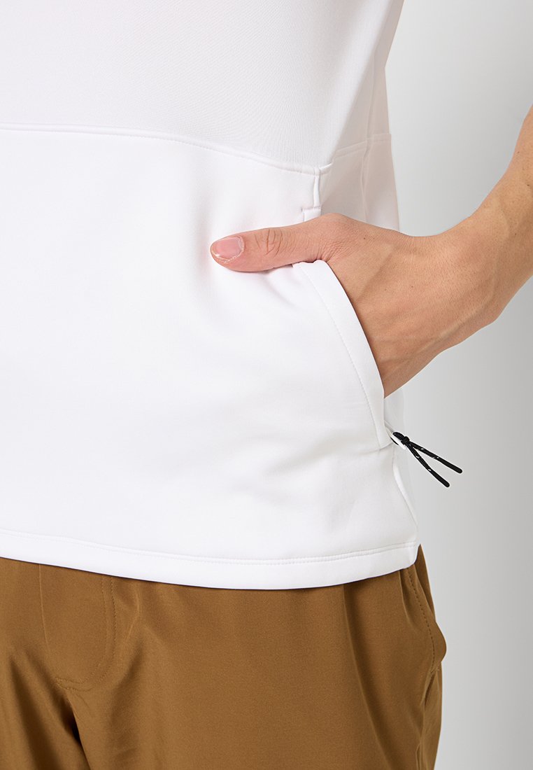 Chemisette blanche à manches courtes avec une poche latérale et un cordon de serrage ajustable. La chemisette a une texture lisse et une coupe décontractée.