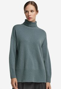 Överdimensionerad polotröja i mjuk teal, med ribbade  ärmslut och fåll. Tillverkad av texturerad stickad tyg för en bekväm passform.