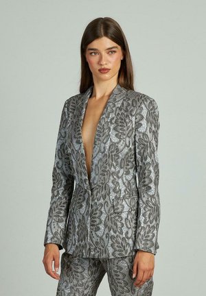 Blazer plateado con diseño floral, escote en V profundo, corte entallado, tejido texturizado y silueta estructurada. Presenta pantalones a juego.