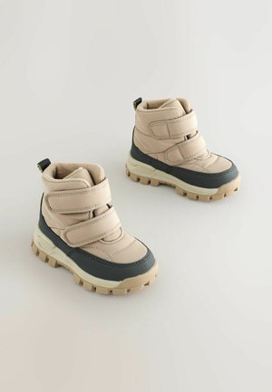 Scarpe da trekking color nocciola e grigie con cinturini in Velcro, colletto imbottito, suole in gomma e una finitura testurizzata. Trazione notevole sulla suola.
