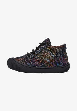 Kinderschwarzer Schnürsneaker mit mehrfarbigem Punktmuster und schwarzer Gummisohle, seitlich auf weißem Hintergrund gezeigt.