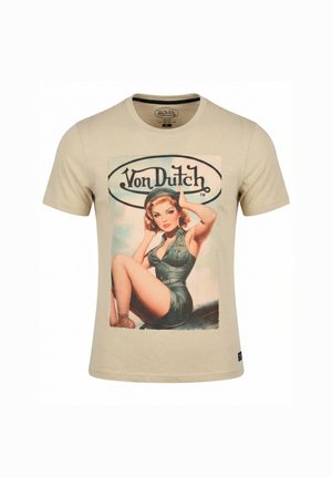 Bež majica Von Dutch z vintage pin-up deklico v zeleni opravi, ki sedi na krilu letala, in logotipom Von Dutch nad njo.