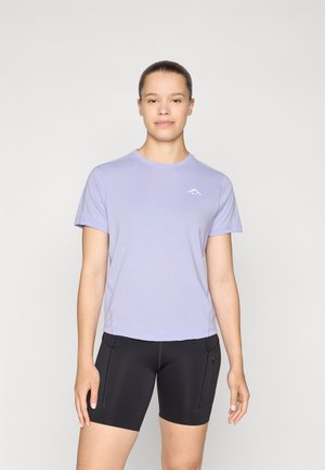 T-shirt à manches courtes violet clair avec un col rond et un logo subtil ; associé à un short noir ajusté avec poches zippées.