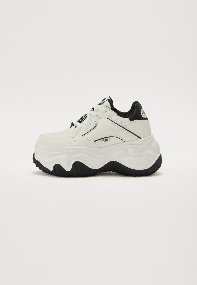 Weißer Sneaker mit schwarzen Akzenten, abgerundeter Form, strukturiertem Sohlenprofil und glattem Leder-Obermaterial. Verfügt über Schnürsenkel und ein Logodetail an der Seite.