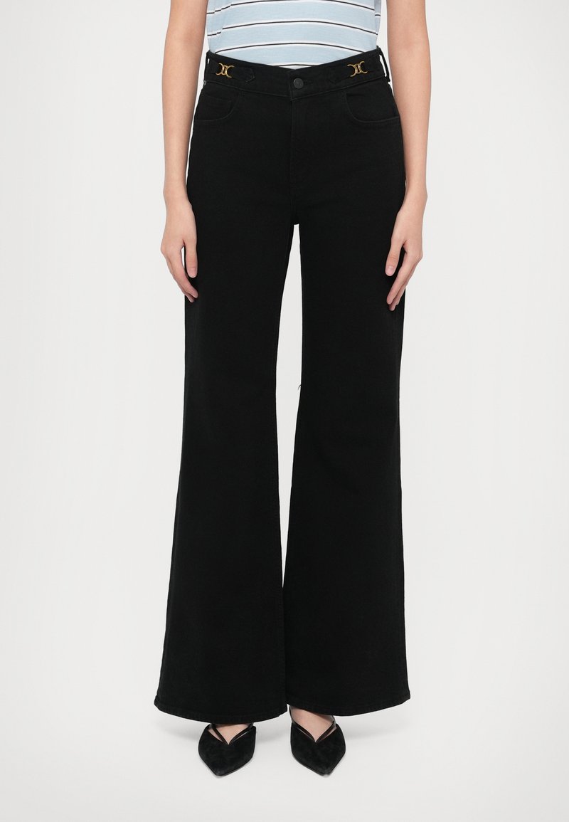 Mustat leveälahkeiset farkut, joissa on kullanväriset yksityiskohdat vyötäröllä, napillinen suljenta ja etutaskut. Sileä kangaspinta.