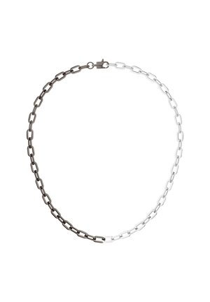 Ketting met rechthoekige schakels, half in zwart metaal en half in zilverkleurig metaal, vastgemaakt met een kleine sluiting.