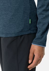 Langermet skjorte i mørkeblå strukturert stoff med en grønn etikettaccent. Har en kontrasterende lys blå mansjettkant og en figursydd design.
