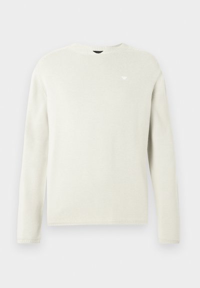 Ανοιχτό γκρι μακρυμάνικη πλεκτή ζακέτα με στρογγυλή λαιμόκοψη, ριμπ υφή και διακριτική λεπτομέρεια λογότυπου στο στήθος. Μαλακό, καθημερινό σχέδιο.