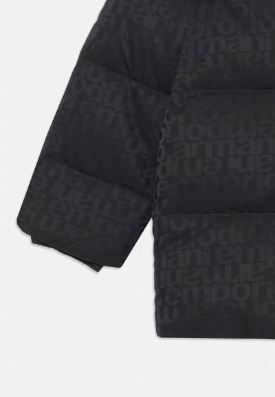 Zwarte, gewatteerde pufferjack met een herhalend tonale logopatroon, brede manchetten en een soepele, glanzende textuur.