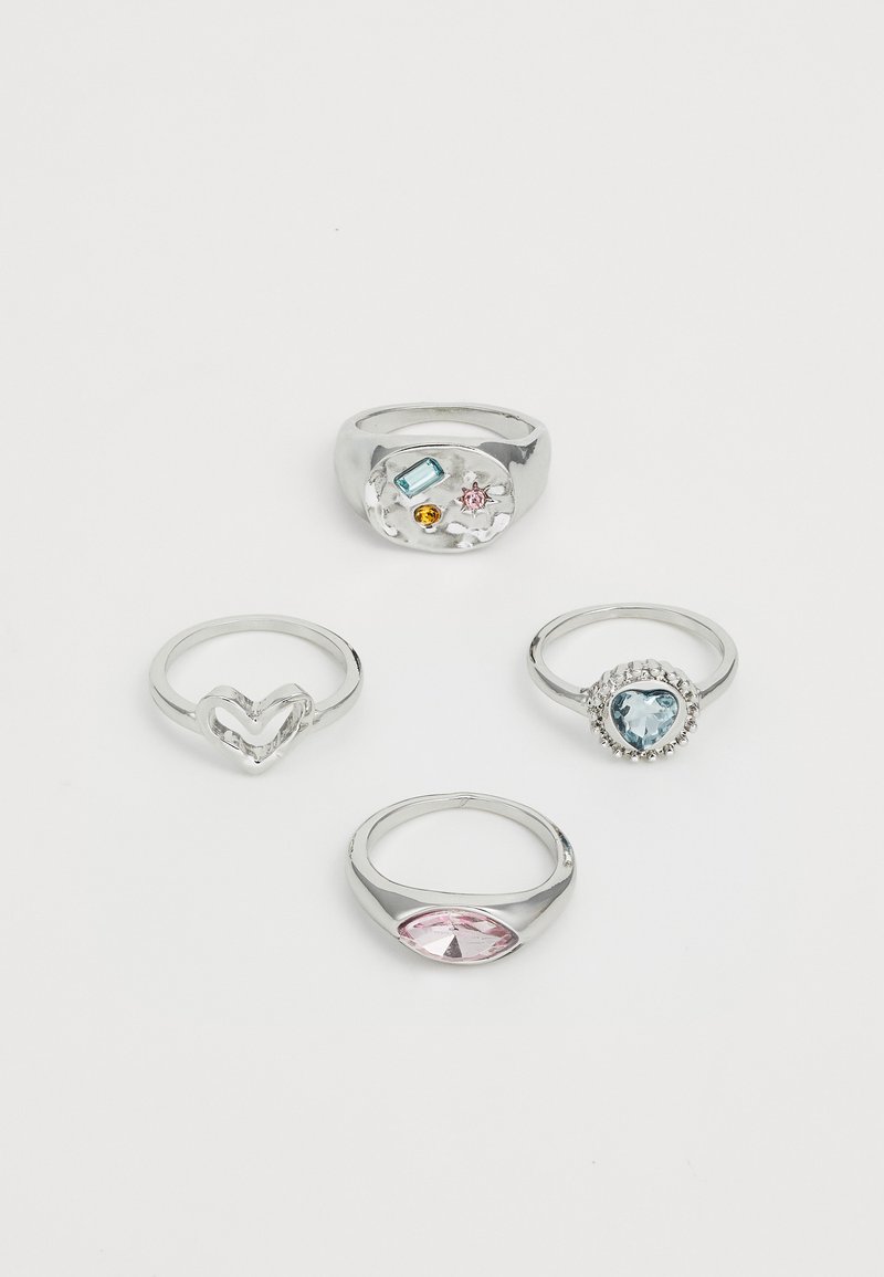 Cuatro anillos: un anillo de plata maciza con gemas de colores, una banda en forma de corazón, un anillo de piedra redonda con acentos azules y un anillo ovalado de cabujón rosa.