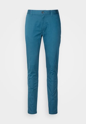 Chinos en coton bleu avec une coupe ajustée, texture lisse, fermeture à bouton à l'avant et passants de ceinture. Pas de motifs ni d'ornements visibles.