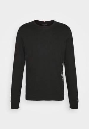 Schwarzes Langarm-T-Shirt aus Baumwolle. Mit Rundhalsausschnitt, gerippten Bündchen und einem kleinen Logodetail an der Seite. Glatte Textur.