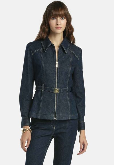 Jeansjacke in Dunkelblau mit durchgehendem Reißverschluss, spitzem Kragen und tailliertem Gürtel. Mit kontrastierender Naht und einem Schößchen-Schnitt.