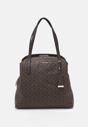 Sac à main marron Calvin Klein avec motif répété du logo CK, double bandoulière et petites étiquettes métalliques de marque à l'avant.