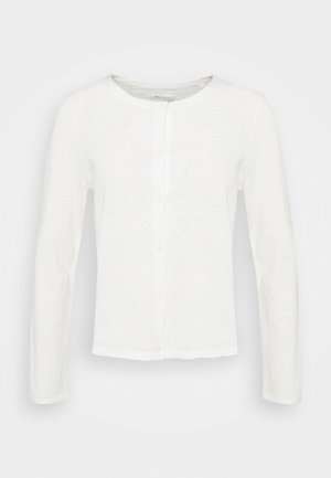 Cardigan blanc à manches longues avec boutons et col rond, en tissu légèrement texturé, présenté sur un fond uni.