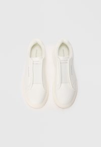 Pair of white slip-on sneakers with textured toe caps and elastic bands, branded "Jack & Jones" on tongue and sides, on white background.