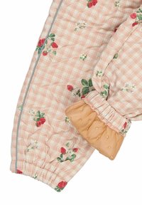 Børnebukser med blomsterprint i lyserødt ternet stof med elastiske manchetter og en struktureret abrikosfarvet detalje ved kanten.