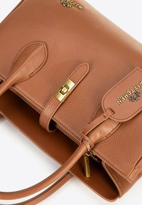 Borsa in pelle marrone con texture, hardware dorato, doppio manico e chiusura magnetica. Presenta un marchio prominente e un'etichetta removibile.