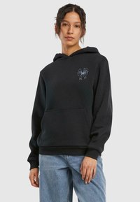 Haut à capuche noir en tissu doux, avec une poche avant et un graphique de ruban bleu clair sur la partie gauche de la poitrine.