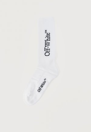 Chaussette blanche à tige courte avec le logo "Off-White™" noir imprimé verticalement sur le mollet et horizontalement sur la semelle du pied.