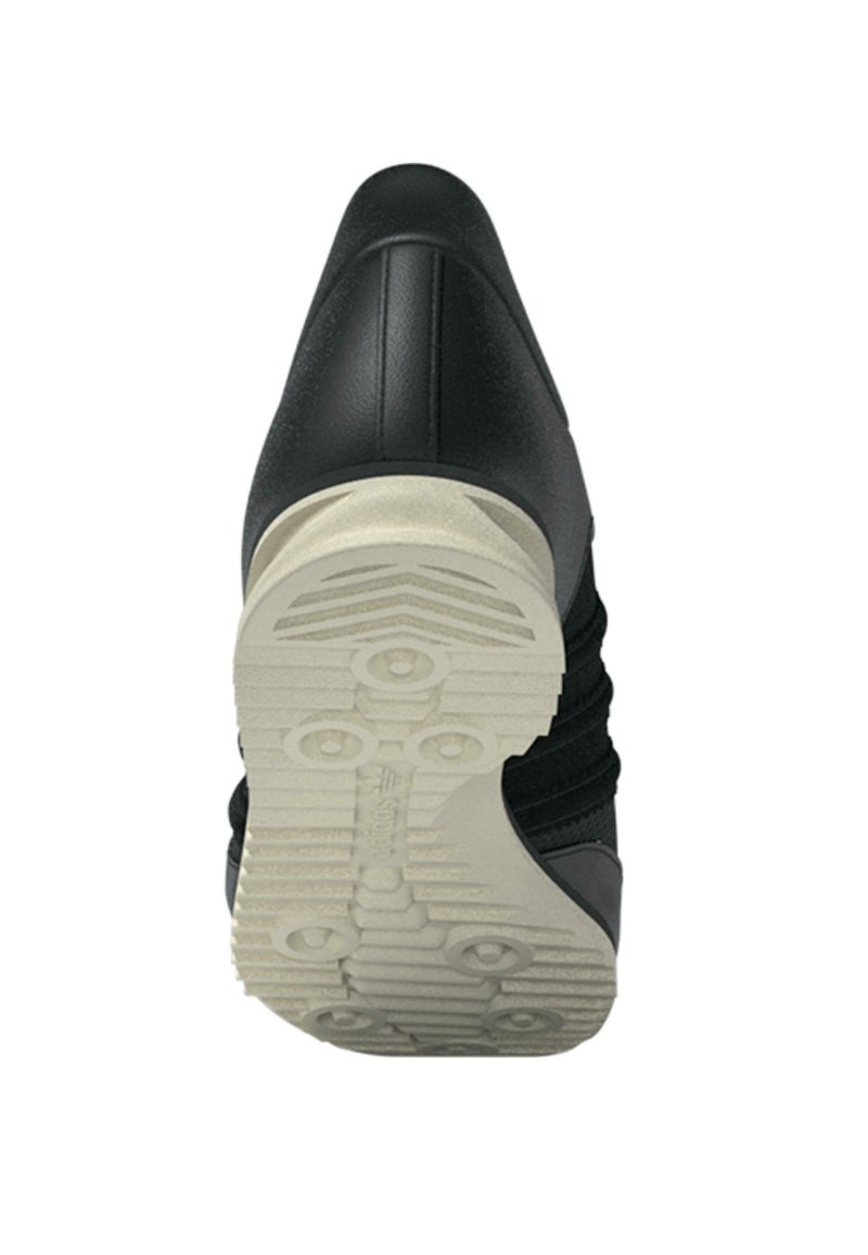 Sort sneakers med en glat læderoverdel og teksturerede stofdetaljer. Har en hvid gummiydersål med et mønstret greb for bedre traction.