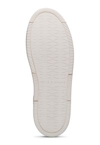 Suola di scarpa in gomma bianca con una superficie testurizzata che presenta motivi ondulati e un logo con la scritta "VOILE BLANCHE." Sono visibili scanalature circolari e rettangolari.