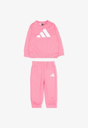 Różowy komplet dresowy z długim rękawem i spodniami z elastyczną talią i ściągaczami, z białym logo Adidas na bluzie i spodniach.