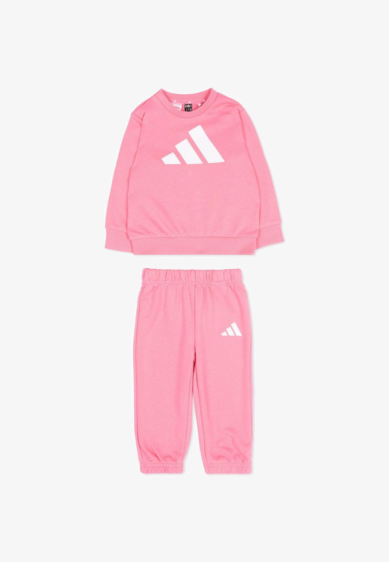 Ensemble sweat-shirt à manches longues et pantalon rose avec taille et poignets élastiques, arborant le logo Adidas blanc sur le haut et le pantalon.