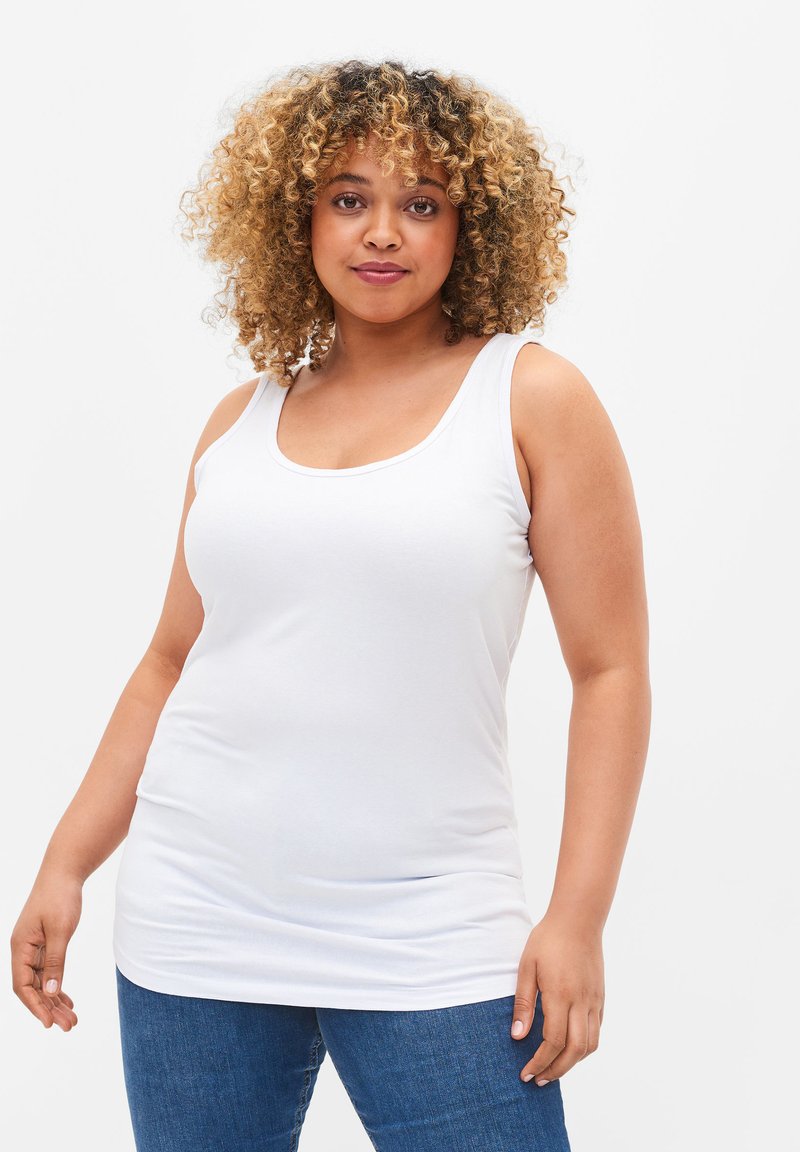 Camiseta sin mangas blanca hecha de una tela suave, con escote en forma de barco, silueta entallada y un dobladillo trasero ligeramente más largo.