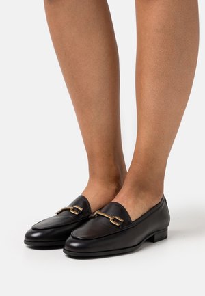 Czarne skórzane mokasyny z niskim obcasem, z ozdobnym złotym łańcuchem z przodu i gładką teksturą. Okrągły kształt czubka.