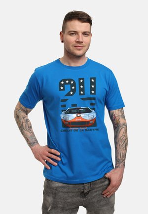 Niebieska koszulka z graficznym motywem vintage wyścigowego samochodu, numerem "24", gwiazdami oraz napisem "Circuit de la Sarthe" w kontrastujących kolorach.