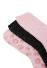 Tre par af fuzzy sokker: lys pink med leopardmønster, ensfarvet sort og en anden lys pink. Blød tekstur og varierede farver.