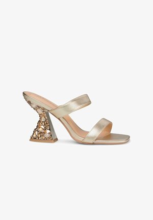 Gouden metallic sandaal met twee banden, voorzien van een driehoekige hak versierd met heldere en gouden stenen. Glad textuur, open teen ontwerp.