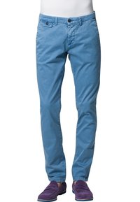 Ljusblå chinos med rak passform, som har två framfickor och knappstängning. Bärs med lila mockaskor.