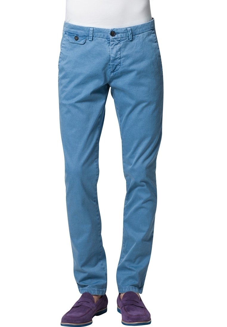 Ljusblå chinos med rak passform, som har två framfickor och knappstängning. Bärs med lila mockaskor.