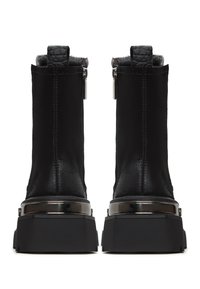 Schwarze Stiefeletten mit glatter Oberfläche, metallischen Akzenten und dicken schwarzen Gummisohlen. Das Innere hat eine weiche graue Fütterung und einen Reißverschluss.
