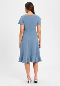 Blaues knielanges Kleid mit kurzen Ärmeln, tailliertem Schnitt, ausgestelltem Rock und einem Volantsaum. Glattes Material mit einem Reißverschluss auf der Rückseite.