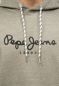 Ανοιχτό γκρι φούτερ με κουκούλα, λευκά και μαύρα κορδόνια και μαύρο λογότυπο "Pepe Jeans London" τυπωμένο στο στήθος.