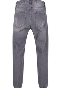Jeans de mezclilla gris con corte tapered, que cuentan con cinco bolsillos, cremallera en la bragueta y una textura deslavada. La vista trasera muestra dos bolsillos parche.