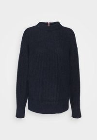 Pull en maille côtelée bleu marine avec un col montant et des manches longues. Caractérisé par une texture subtile et un détail à l'arrière avec des accents rouges et blancs.