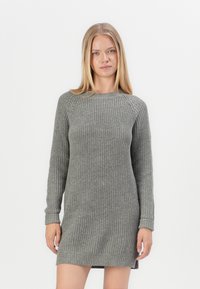 Világosszürke kötött ruha, bordázott textúrával, hosszú ujjakkal és kerek nyakkivágással. Enyhén laza fazonú, oldalsó hasítékokkal rendelkezik.