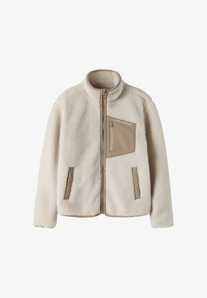 Veste polaire beige avec fermeture éclair intégrale à l'avant et une poche poitrine avec fermeture éclair et tissu marron avec le texte "STUDIO OUTDOORS".
