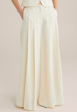 Weite, cremefarbene Leinenhose mit vorderen Falten und seitlichen Taschen. Glatte Textur mit einem klaren, minimalistischen Design.