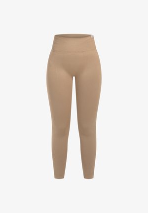 Beige high-waisted leggings van rekbaar materiaal, met een gladde textuur en een strakke pasvorm, die taps toelopen bij de enkel.
