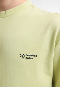 Lichtgroen T-shirt van katoen, met een ronde hals en korte mouwen. Zwart tekstlogo "Petrolind Daytona" nabij de onderkant.